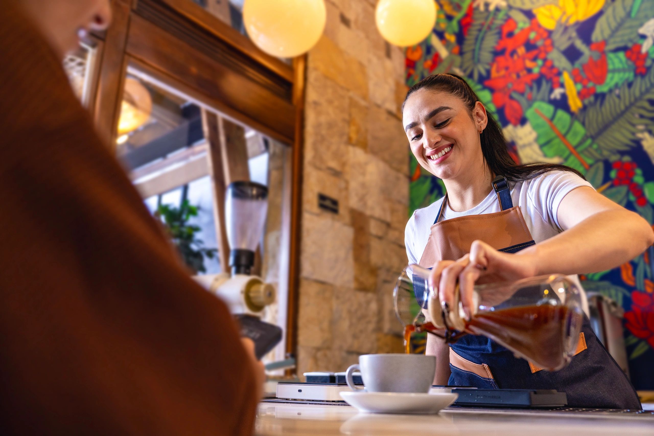 Barista serving fresh coffee in a modern café